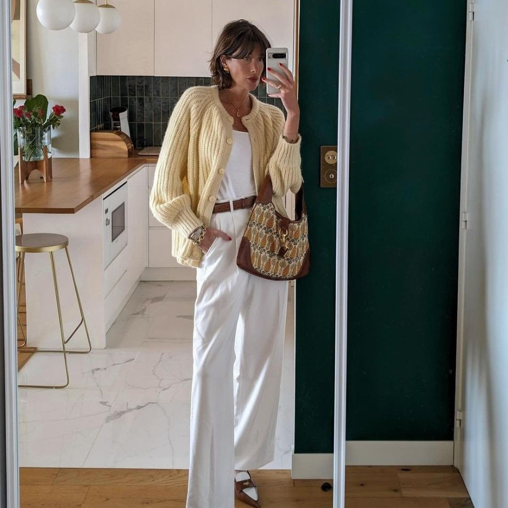 40 year old woman wearing butter yellow cardigan with all cream outfit.
