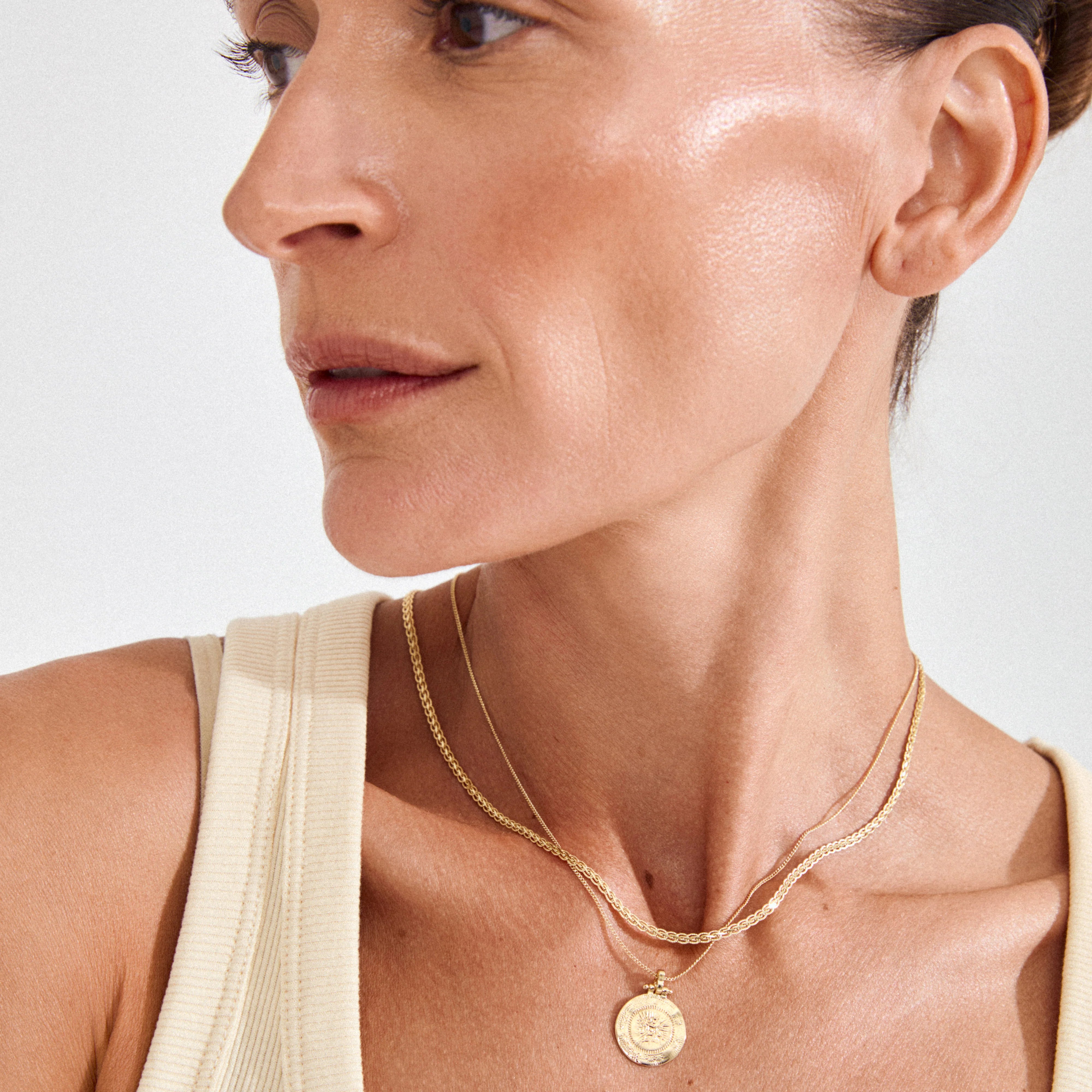 gold layered necklace women featuring textured chain and medallion charm