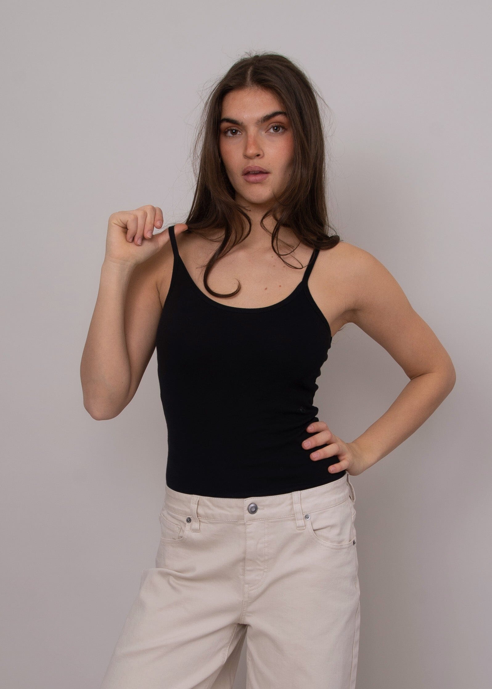 sleek black tank outfit, black tank for layering outfits, simple black top women fashion, wardrobe staple black tank, fitted camisole tank black