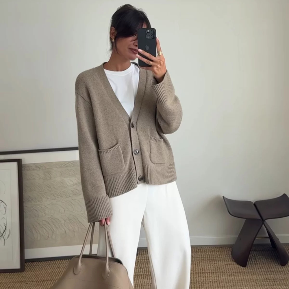 woman wearing neutral colored cardigan layered over a white tshirt and white pants