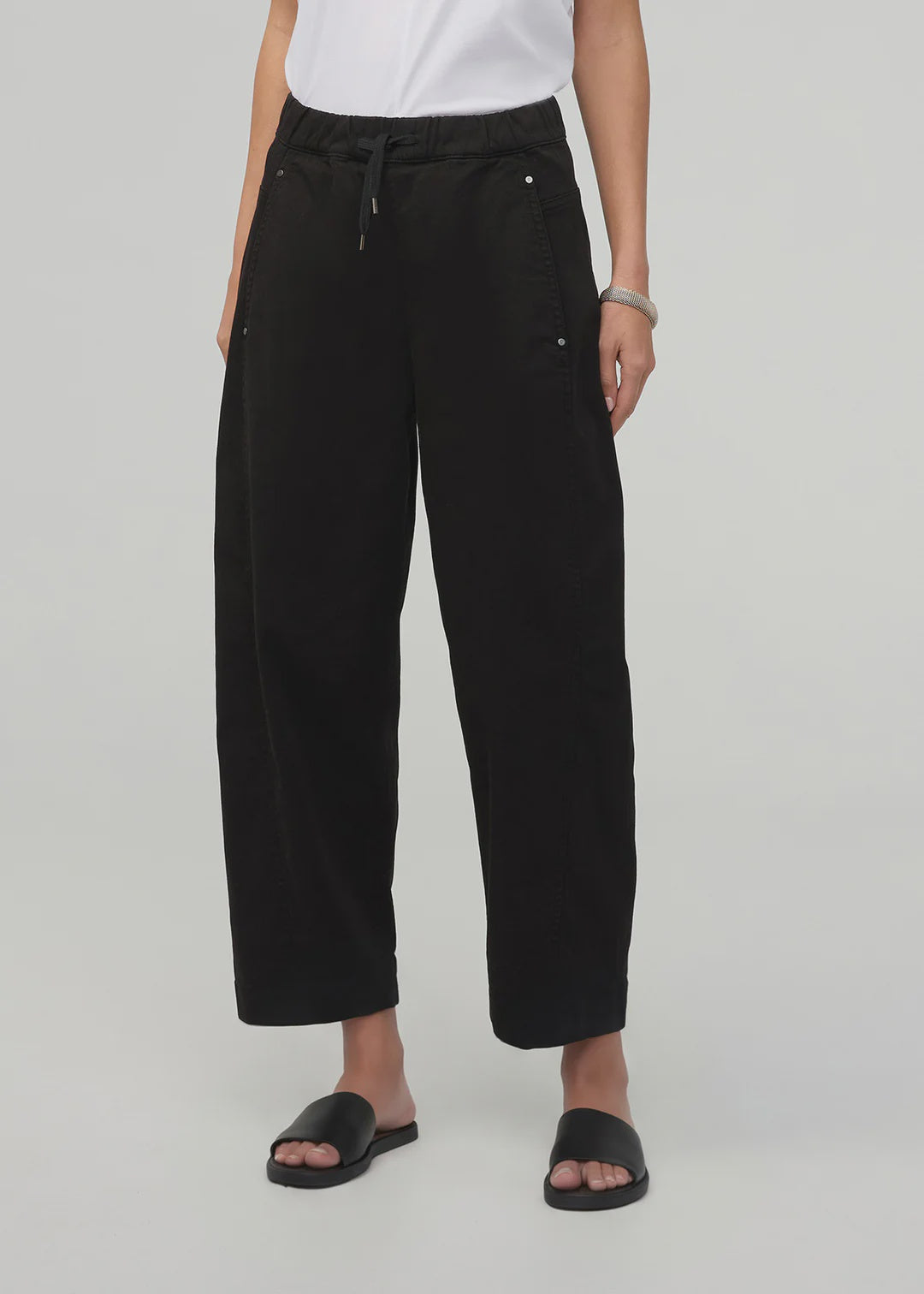 Person wearing black pants on a white background
