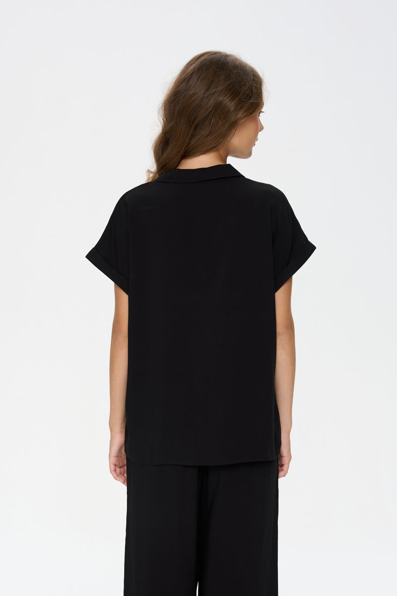 effortless black outfit, elevated basics women, black short sleeve blouse, polished casual style