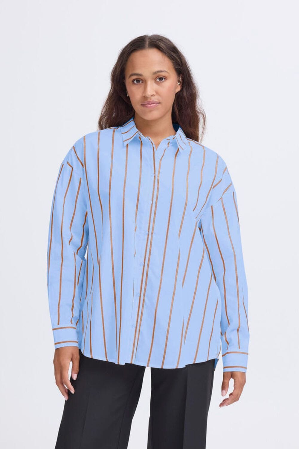 Woman wearing oversized blue striped button down shirt with brown vertical stripes, ICHI 