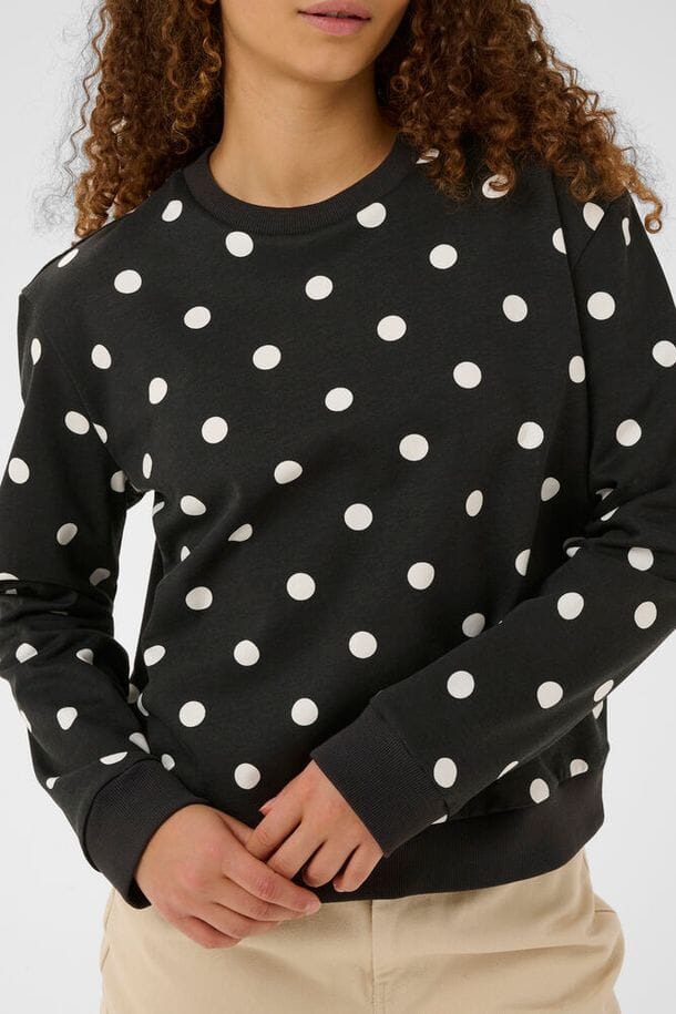 modern polka dot sweater, stylish casual women top, transitional season sweatshirt, cute printed sweater women, fall layering sweatshirt, spring layering pullover, boutique style polka dot top, black long sleeve spotted top, fashion forward sweatshirt women, neutral wardrobe staple sweater